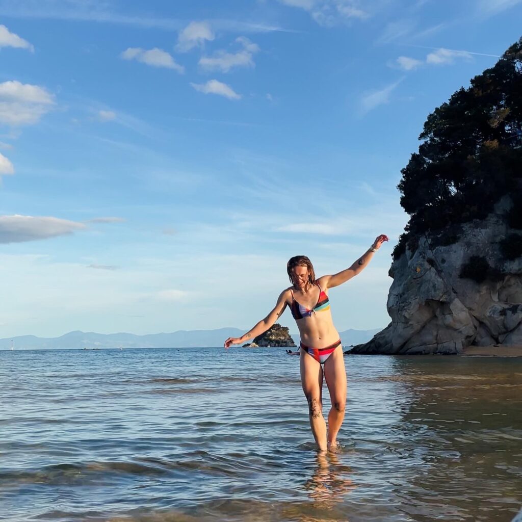 Athletic woman in bikini on beach in Kaiteriteri, New Zealand